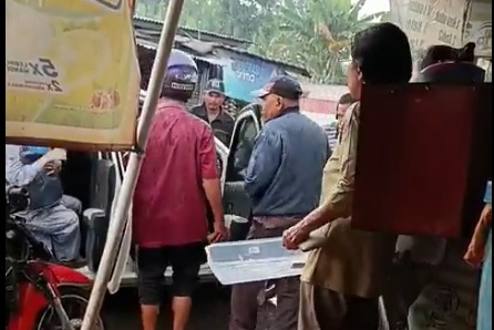 Momem saat seorang ibu dan anak balitanya terpaksa turun dari taksi online di tengah hujan setelah kendaraan mereka diadang oleh sekelompok opang di Stasiun Tigaraksa, Kabupaten Tangerang, Banten, Jumat (25/7), (X@txtdaritng)